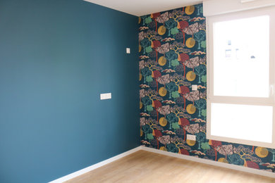 Cette image montre un salon de taille moyenne avec un mur bleu et du papier peint.