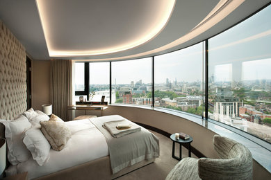 This is an example of a large contemporary guest bedroom in London with beige walls, carpet, no fireplace and beige floor.