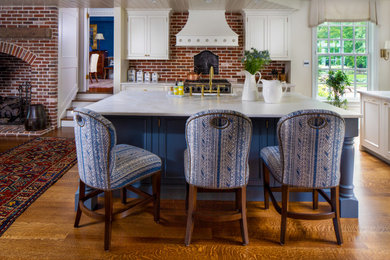 Photo of a large traditional eat-in kitchen in Philadelphia with a farmhouse sink, beaded inset cabinets, blue cabinets, quartzite benchtops, brick splashback, stainless steel appliances, dark hardwood floors, multiple islands, brown floor, multi-coloured benchtop and wood.