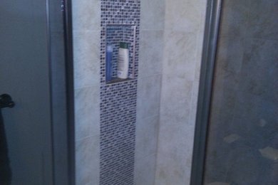 Alcove shower - small transitional 3/4 porcelain tile alcove shower idea in Other with raised-panel cabinets, white cabinets, a two-piece toilet, white walls, a drop-in sink and a hinged shower door