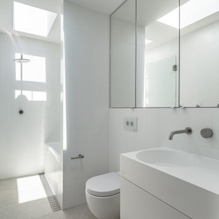 Design ideas for a modern wet room bathroom in Sydney with flat-panel cabinets, white cabinets, an alcove tub, a wall-mount toilet, white tile, an integrated sink, grey floor, an open shower, white benchtops, a single vanity and a floating vanity.