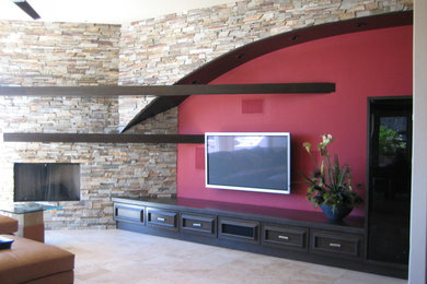 Example of a large trendy open concept porcelain tile living room design in Phoenix with red walls, a standard fireplace, a stone fireplace and a wall-mounted tv