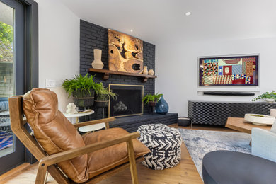 Diseño de salón para visitas cerrado contemporáneo de tamaño medio con suelo de madera en tonos medios, marco de chimenea de ladrillo, televisor colgado en la pared y suelo blanco