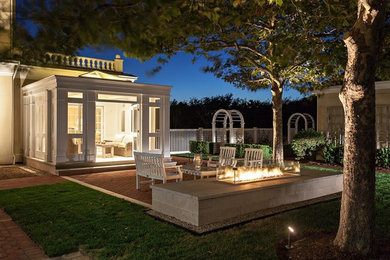 This is an example of a large backyard brick landscaping in Boston with a fire pit.