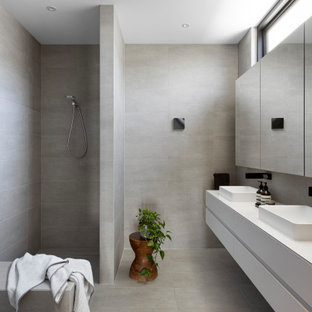 Design ideas for a large modern master bathroom in Melbourne with flat-panel cabinets, white cabinets, an open shower, gray tile, ceramic tile, ceramic floors, engineered quartz benchtops, grey floor, an open shower, white benchtops, a shower seat, a double vanity and a floating vanity.
