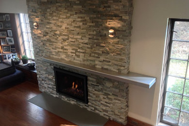 Inspiration for a contemporary family room remodel in Philadelphia with a standard fireplace and a stone fireplace