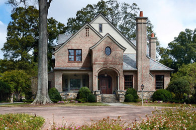 Large traditional brown two-story brick exterior home idea in Charlotte with a shingle roof