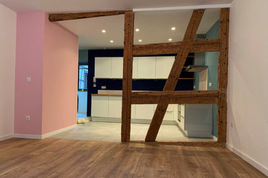 Exemple d'une cuisine ouverte tendance en L de taille moyenne avec des portes de placard blanches, un plan de travail en bois, un sol en carrelage de céramique et un sol gris.