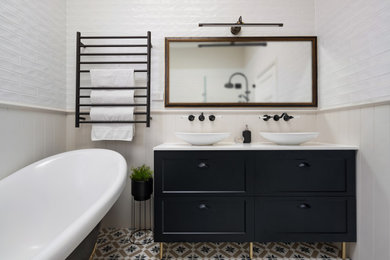 Photo of a mid-sized traditional bathroom in Sydney with shaker cabinets, black cabinets, a claw-foot tub, a corner shower, white tile, subway tile, a vessel sink, engineered quartz benchtops, a hinged shower door, white benchtops, a double vanity, a freestanding vanity, beige walls, mosaic tile floors, multi-coloured floor and panelled walls.