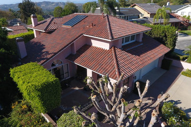 Example of a mid-sized tuscan beige two-story stucco exterior home design in Orange County with a tile roof