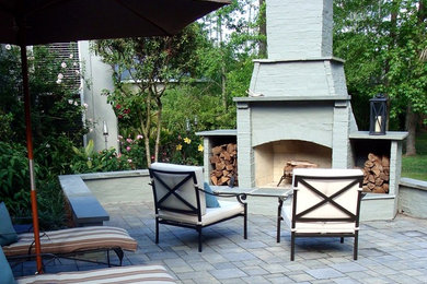 Photo of a mid-sized traditional backyard patio in New Orleans with a fire feature, natural stone pavers and no cover.