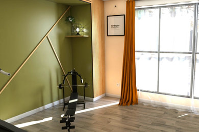 Cette photo montre une salle de musculation moderne de taille moyenne avec un mur vert, un sol en linoléum et un sol gris.