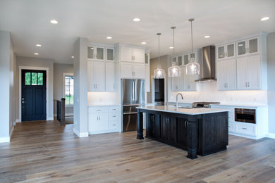 Kitchen - large transitional l-shaped light wood floor kitchen idea in Other with a farmhouse sink, flat-panel cabinets, white cabinets, quartzite countertops, white backsplash, ceramic backsplash, stainless steel appliances, an island and white countertops