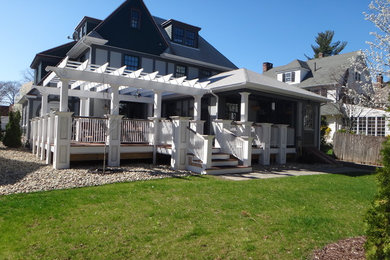 Large arts and crafts gray two-story stucco house exterior photo in Bridgeport with a hip roof and a shingle roof