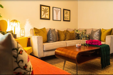 Living room - mid-sized eclectic formal and enclosed laminate floor and brown floor living room idea in West Midlands with gray walls and a tv stand