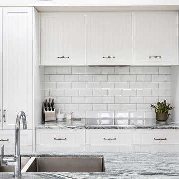 Black and white granite benchtop with white cabinets