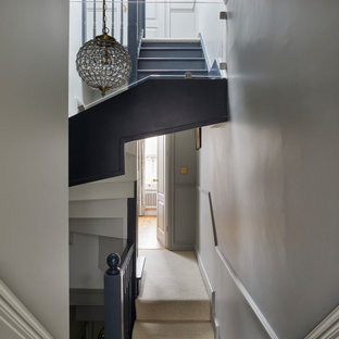 Kleine Klassische Treppe mit Teppich-Setzstufen, Holzgeländer und Holzdielenwänden in London