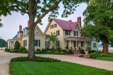 Traditional yellow two-story exterior home idea in Baltimore with a mixed material roof