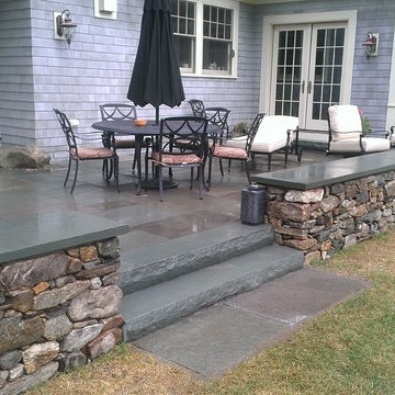 Blue stone patio and New England fieldstone capped sitting wall