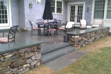 Blue stone patio and New England fieldstone capped sitting wall