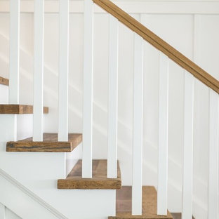 Foto de escalera recta, clásica, de tamaño medio, con escalones de madera, contrahuellas de madera pintada y barandilla de madera