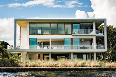 Expansive contemporary three-storey concrete white exterior in Miami.