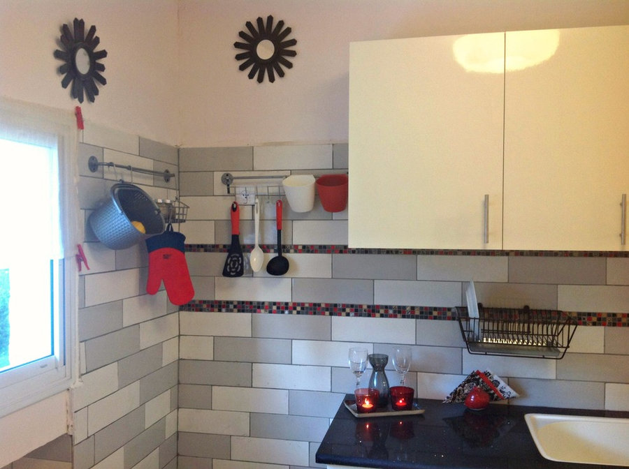 subway tiles in gray and white with blk/red mosaic strip