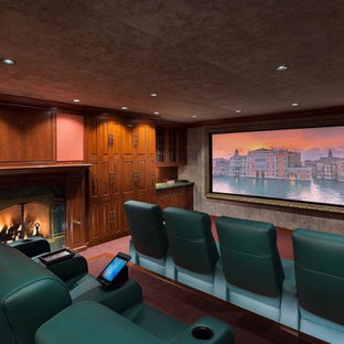 Cette image montre une grande salle de cinéma traditionnelle fermée avec un mur rose, moquette, un écran de projection et un sol rose.