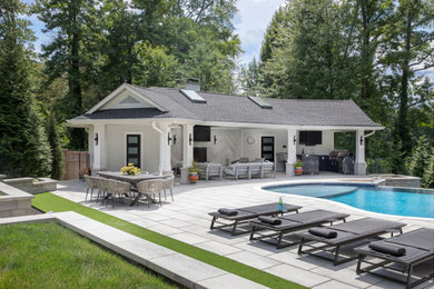 Pool house - large contemporary backyard concrete paver and custom-shaped infinity pool house idea in Newark
