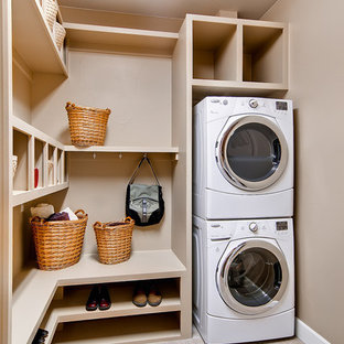 Inspiration for a mid-sized timeless beige floor utility room remodel in Denver with a stacked washer/dryer and beige walls