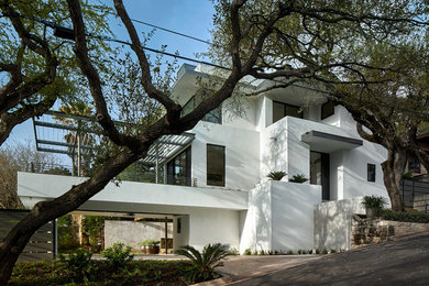 Mid-sized trendy white three-story stucco flat roof photo in Austin