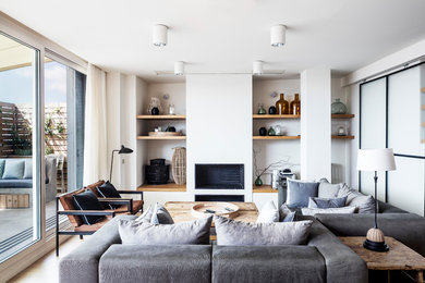 Eclectic open concept living room in Barcelona with white walls and medium hardwood floors.