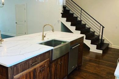 Example of a mid-sized minimalist u-shaped dark wood floor and brown floor eat-in kitchen design in Oklahoma City with a farmhouse sink, flat-panel cabinets, medium tone wood cabinets, quartz countertops, stainless steel appliances, an island and white countertops