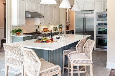 Eat-in kitchen - mid-sized transitional u-shaped porcelain tile and gray floor eat-in kitchen idea in Houston with an undermount sink, raised-panel cabinets, green cabinets, quartz countertops, multicolored backsplash, porcelain backsplash, stainless steel appliances, an island and white countertops