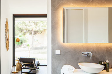На фото: большая главная ванная комната в стиле модернизм с отдельно стоящей ванной, унитазом-моноблоком, серой плиткой, плиткой из сланца, столешницей из ламината, белой столешницей и тумбой под две раковины с