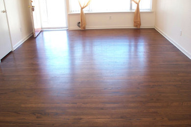 Example of a mid-sized classic enclosed medium tone wood floor living room design in Dallas with white walls