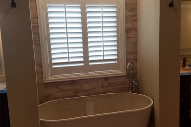 リッチモンドにある低価格の小さなコンテンポラリースタイルのおしゃれなマスターバスルーム (家具調キャビネット、置き型浴槽、モノトーンのタイル、大理石タイル) の写真