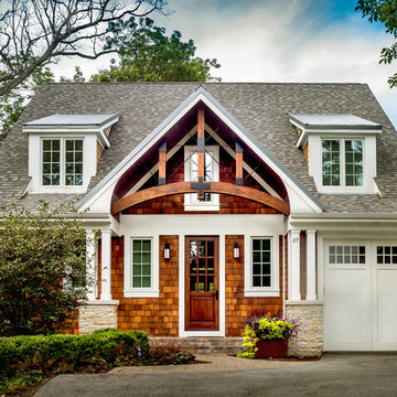 Craftsman features shed dormers and square columns on stone piers