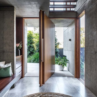 ブリスベンの回転式ドアモダンスタイルのおしゃれな玄関 (木目調のドア、グレーの床) の写真