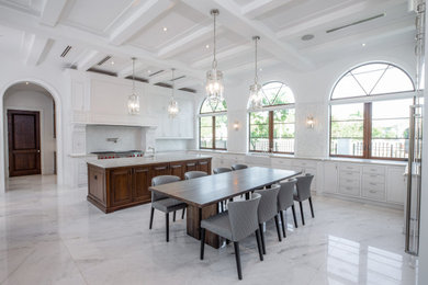Design ideas for an expansive transitional u-shaped eat-in kitchen in Miami with a farmhouse sink, shaker cabinets, white cabinets, stainless steel appliances, marble floors, with island, grey floor, granite benchtops, grey splashback and beige benchtop.
