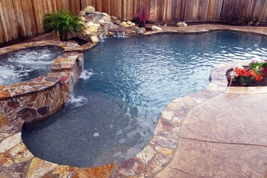 Example of a large backyard stone and custom-shaped natural hot tub design in San Francisco