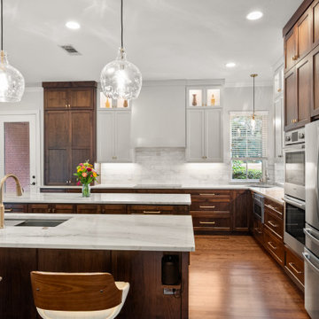 Close-up of walnut kitchen island with gold faucet and glass pendants