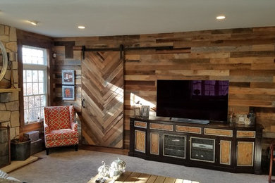 Example of a mid-sized mountain style enclosed dark wood floor family room design in New York with a standard fireplace, a stone fireplace and a tv stand