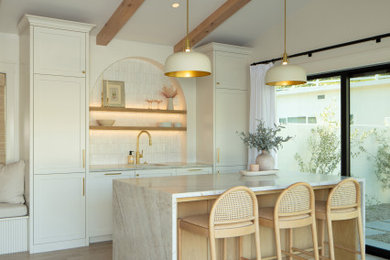 Example of a mid-sized beach style single-wall light wood floor and beige floor seated home bar design in San Luis Obispo with an undermount sink, shaker cabinets, white cabinets, quartz countertops, white backsplash and white countertops
