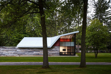Example of a mid-sized urban one-story mixed siding house exterior design in Grand Rapids with a shed roof and a metal roof