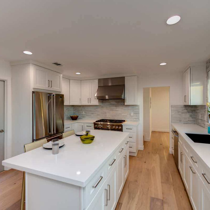 Eat-in kitchen - mid-sized contemporary u-shaped light wood floor eat-in kitchen idea in Los Angeles with an undermount sink, shaker cabinets, white cabinets, quartz countertops, white backsplash, mar