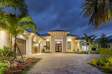 Large contemporary gray one-story stucco exterior home idea in Other with a tile roof