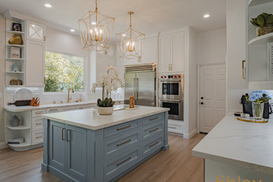 Inspiration for a large coastal brown floor kitchen remodel in Orange County with blue cabinets, white backsplash, ceramic backsplash, stainless steel appliances and an island