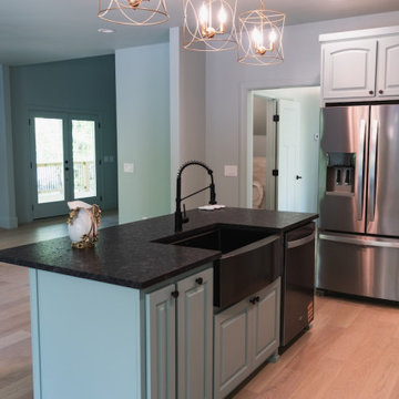Modern Kitchen Island with Soft Teal Cabinetry and Geometric Gold Lighting