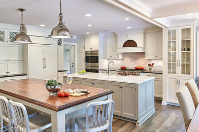 Photo of an expansive transitional eat-in kitchen in New York with beaded inset cabinets, marble benchtops, beige splashback, ceramic splashback, white appliances, medium hardwood floors, multiple islands and grey cabinets.